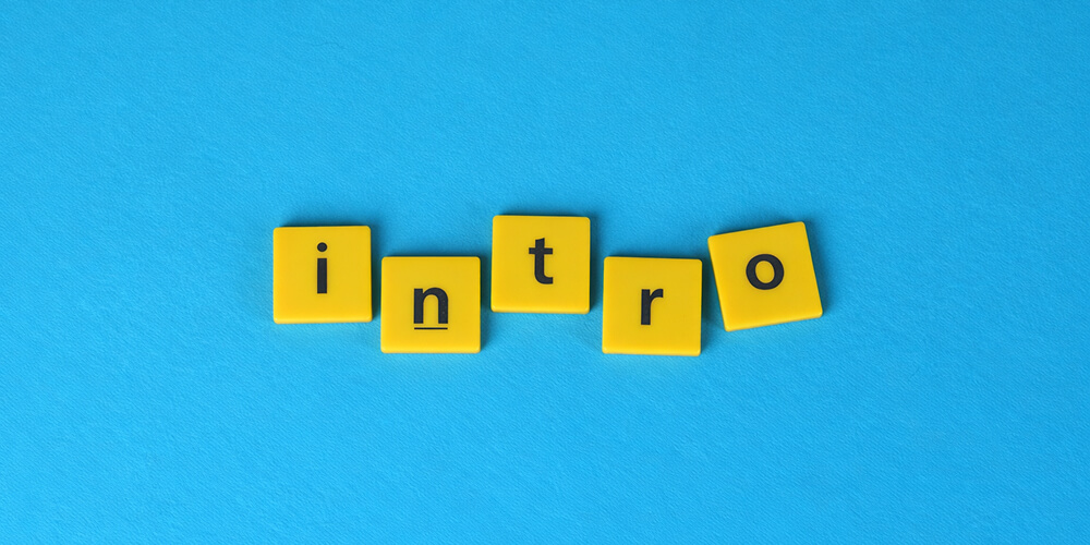 Lettres jaunes en cubes formant le mot « intro » sur fond bleu, illustration minimaliste pour introduction de contenu.