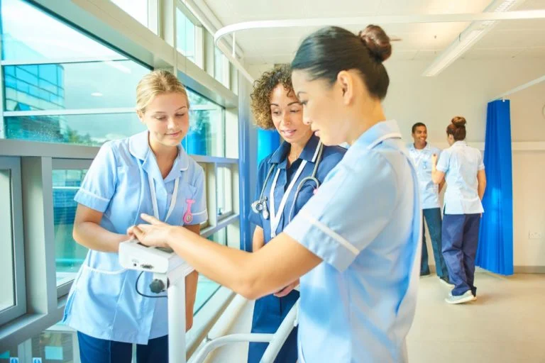Étudiantes infirmières en stage apprenant à utiliser un dispositif de mesure en milieu hospitalier